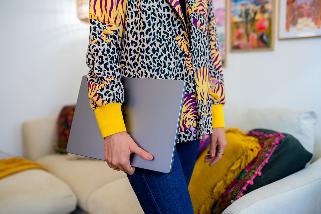 Bright home office setup with plants, art, and laptop, representing productivity tips for remote entrepreneurs.